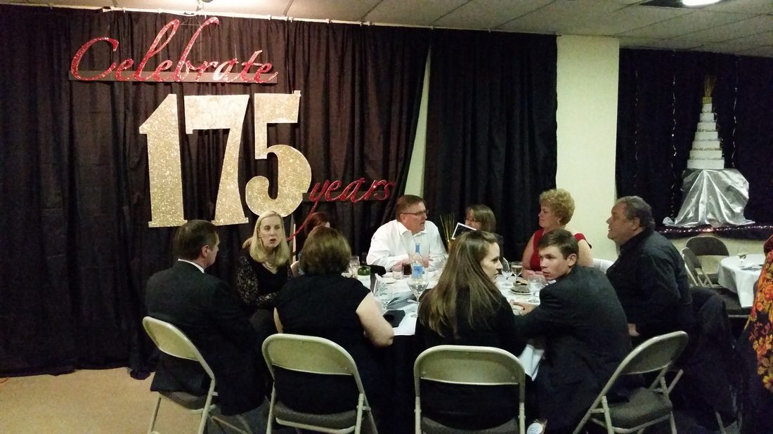 People talking at table at the 175th anniversary of the church